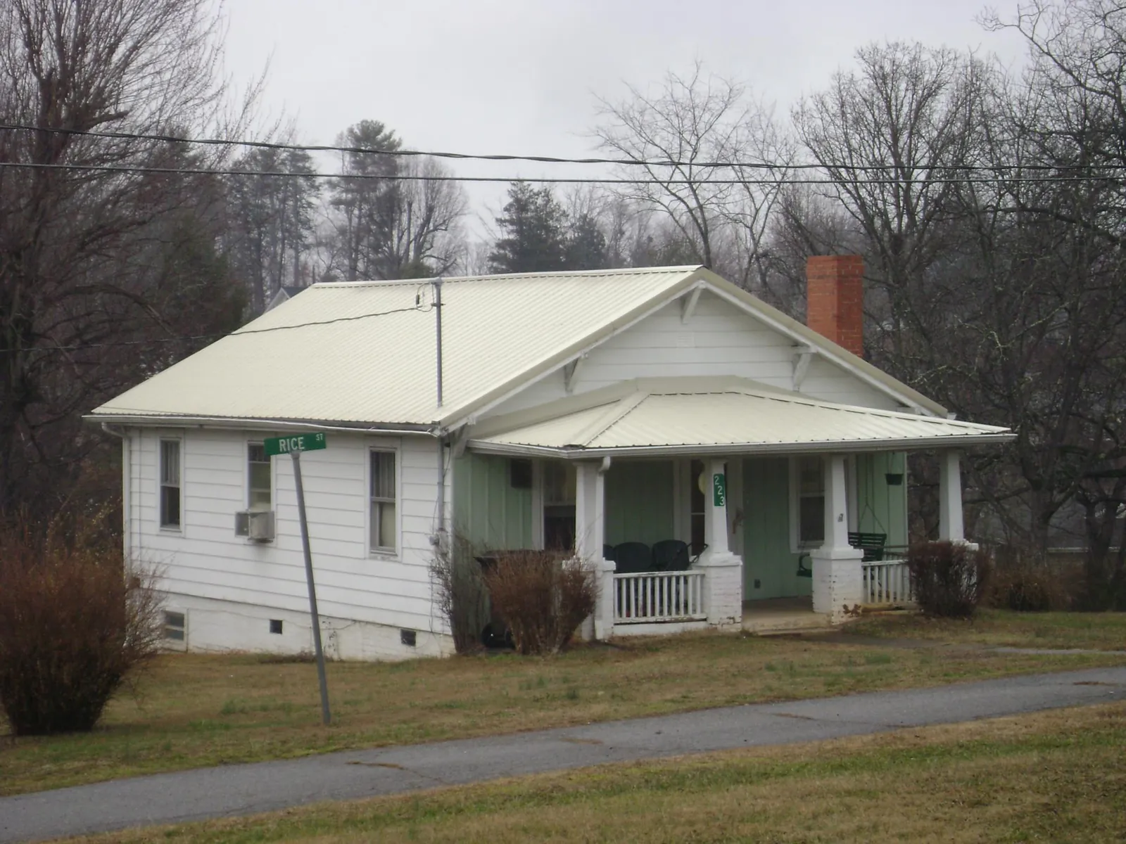 White metal roof on a craftsman bungalow at a street corner in Greensboro